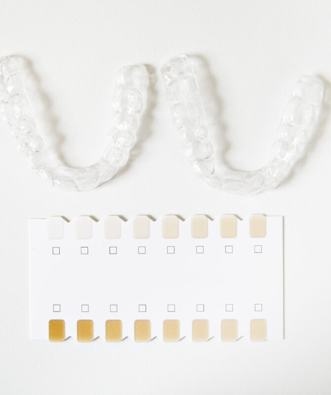 two dental whitening trays and a palette for tooth color